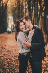 Beautiful young couple hugging in autumn park.