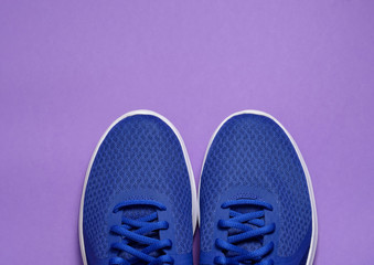 Sport sneakers on purple background with copy space for text. Sport objects background. Sports concept