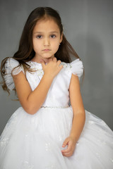Portrait of a beautiful little oriental girl in a white dress.