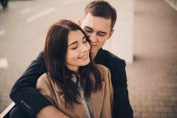 Loving couple hug sitting on the street.