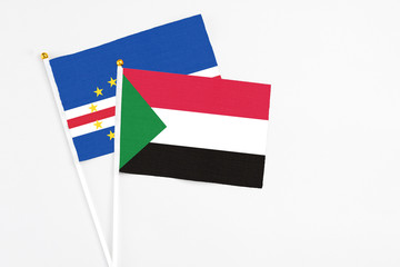 Sudan and Cape Verde stick flags on white background. High quality fabric, miniature national flag. Peaceful global concept.White floor for copy space.