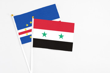 Syria and Cape Verde stick flags on white background. High quality fabric, miniature national flag. Peaceful global concept.White floor for copy space.