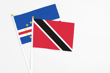 Trinidad And Tobago and Cape Verde stick flags on white background. High quality fabric, miniature national flag. Peaceful global concept.White floor for copy space.