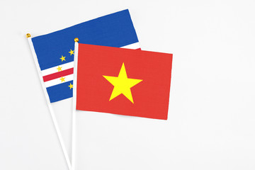 Vietnam and Cape Verde stick flags on white background. High quality fabric, miniature national flag. Peaceful global concept.White floor for copy space.