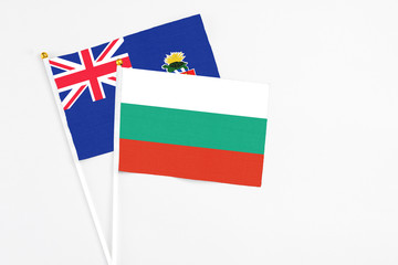 Bulgaria and Cayman Islands stick flags on white background. High quality fabric, miniature national flag. Peaceful global concept.White floor for copy space.