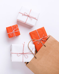 Wrapped gift boxes inside paper bag on white