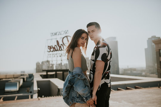 Young urban couple posing on sunny rooftop