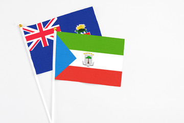 Equatorial Guinea and Cayman Islands stick flags on white background. High quality fabric, miniature national flag. Peaceful global concept.White floor for copy space.