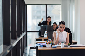 Business woman talking on the mobile phone while sitting at her working place in office