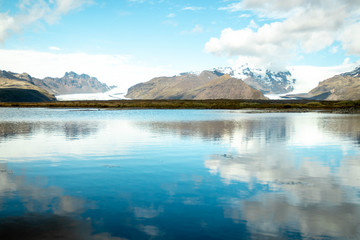 Fototapeta na wymiar View of two glaciers in the mountains and reflective lake along the ring road of Iceland's east coast