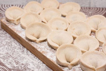 Dumplings - a dish of Russian cuisine on a wooden background. Cooking.