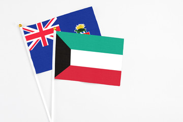 Kuwait and Cayman Islands stick flags on white background. High quality fabric, miniature national flag. Peaceful global concept.White floor for copy space.