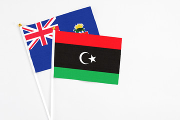 Libya and Cayman Islands stick flags on white background. High quality fabric, miniature national flag. Peaceful global concept.White floor for copy space.