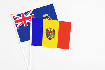 Moldova and Cayman Islands stick flags on white background. High quality fabric, miniature national flag. Peaceful global concept.White floor for copy space.