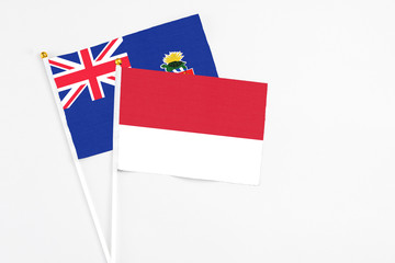 Monaco and Cayman Islands stick flags on white background. High quality fabric, miniature national flag. Peaceful global concept.White floor for copy space.