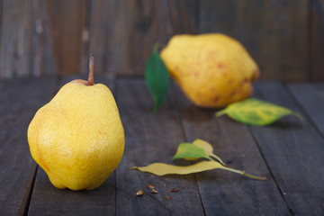 Delicious and juicy Bartlett pears with leaves and seeds on wooden background. Healthy autumn fruit.