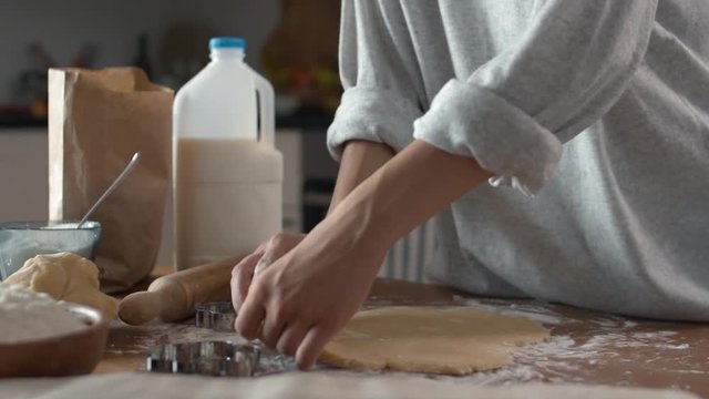 Close up of female hands making cookies of raw dough using special tool