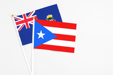 Puerto Rico and Cayman Islands stick flags on white background. High quality fabric, miniature national flag. Peaceful global concept.White floor for copy space.