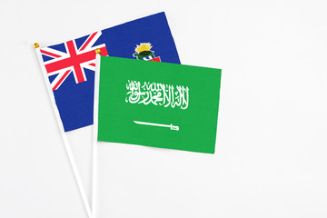 Saudi Arabia and Cayman Islands stick flags on white background. High quality fabric, miniature national flag. Peaceful global concept.White floor for copy space.