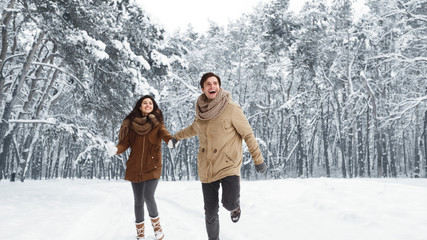 Fototapeta na wymiar Excited Couple Running Through Winter Forest Holding Hands, Panorama
