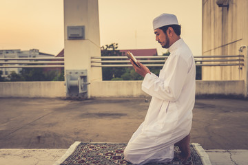 A Young asian muslim man praying on sunset,Ramadan festival concept