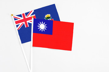 Taiwan and Cayman Islands stick flags on white background. High quality fabric, miniature national flag. Peaceful global concept.White floor for copy space.