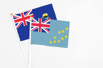 Tuvalu and Cayman Islands stick flags on white background. High quality fabric, miniature national flag. Peaceful global concept.White floor for copy space.