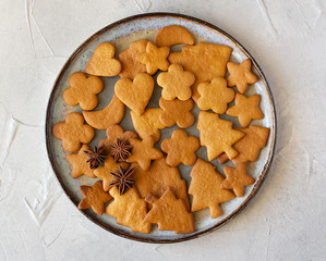 Traditional Christmas gingerbread cookies and anis stars on round plate, top view