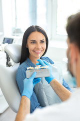 dentist holding teeth color palette choosing color for female patient