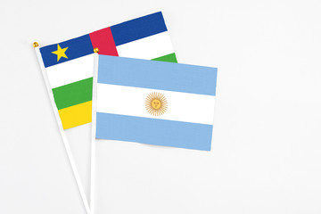 Argentina and Central African Republic stick flags on white background. High quality fabric, miniature national flag. Peaceful global concept.White floor for copy space.