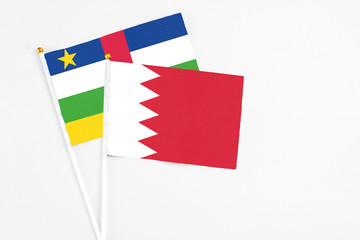 Bahrain and Central African Republic stick flags on white background. High quality fabric, miniature national flag. Peaceful global concept.White floor for copy space.