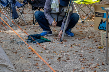 キャンプ場でテントのペグを打つ男性