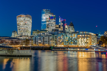 London Evening cityscape with a museum boat and skyscrapers