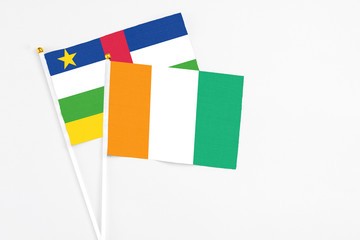 Cote D'Ivoire and Central African Republic stick flags on white background. High quality fabric, miniature national flag. Peaceful global concept.White floor for copy space.