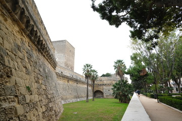 Fototapeta na wymiar Walls of the Norman Swabian castle of Bari. The gardens with green plants and the fort built by Frederick II..
