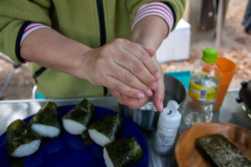 アウトドアでおにぎりを握る女性の手