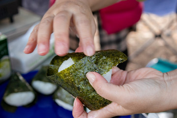 アウトドアでおにぎりを握る女性の手