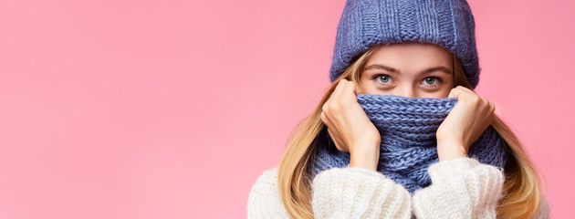Mysterious blonde girl hiding her face with scarf