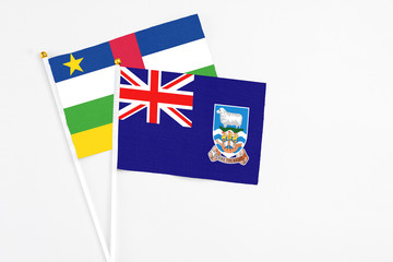 Falkland Islands and Central African Republic stick flags on white background. High quality fabric, miniature national flag. Peaceful global concept.White floor for copy space.