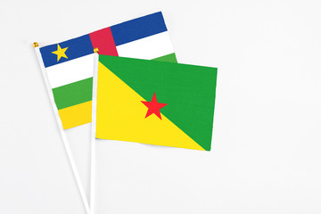 French Guiana and Central African Republic stick flags on white background. High quality fabric, miniature national flag. Peaceful global concept.White floor for copy space.