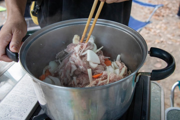 アウトドアで豚汁を作る為に鍋で食材を炒める
