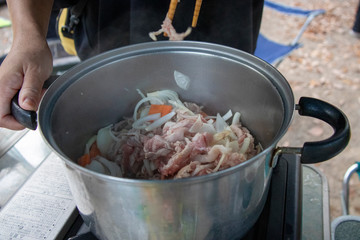 アウトドアで豚汁を作る為に鍋で食材を炒める