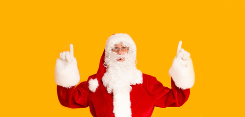 Handsome Santa indicating with hands up on copy space