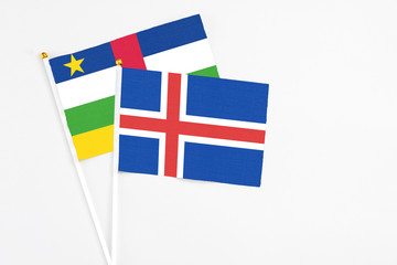 Obraz premium Iceland and Central African Republic stick flags on white background. High quality fabric, miniature national flag. Peaceful global concept.White floor for copy space.