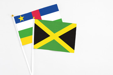 Jamaica and Central African Republic stick flags on white background. High quality fabric, miniature national flag. Peaceful global concept.White floor for copy space.