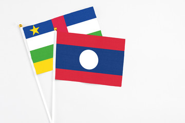 Laos and Central African Republic stick flags on white background. High quality fabric, miniature national flag. Peaceful global concept.White floor for copy space.