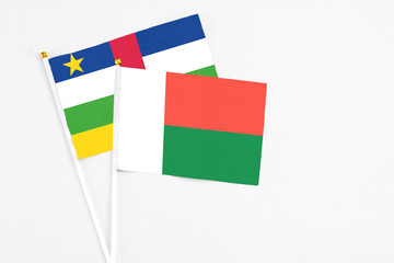 Madagascar and Central African Republic stick flags on white background. High quality fabric, miniature national flag. Peaceful global concept.White floor for copy space.
