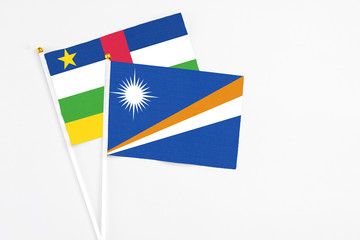 Marshall Islands and Central African Republic stick flags on white background. High quality fabric, miniature national flag. Peaceful global concept.White floor for copy space.