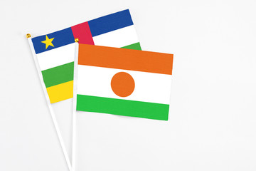 Niger and Central African Republic stick flags on white background. High quality fabric, miniature national flag. Peaceful global concept.White floor for copy space.
