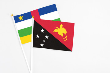 Papua New Guinea and Central African Republic stick flags on white background. High quality fabric, miniature national flag. Peaceful global concept.White floor for copy space.